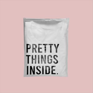 May include: White t-shirt in a clear plastic bag with a zipper closure. The t-shirt has the text "PRETTY THINGS INSIDE." printed in black.
