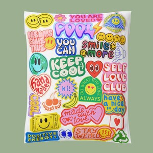 May include: A white pillowcase covered in colorful, whimsical stickers. The stickers feature smiley faces, hearts, and phrases like "Keep Cool," "You Are Loved," and "Smile More." The overall design has a fun, positive vibe.