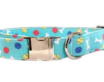 Peut inclure: Un collier pour chien bleu turquoise avec une boucle argentée et un motif d'os blancs, de balles rouges, jaunes et bleues.
