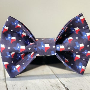 May include: A navy blue bow tie with a repeating pattern of white stars and red, white, and blue Texas state outlines.