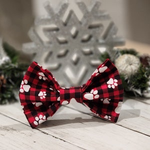 May include: Red and black bow tie with white paw prints.