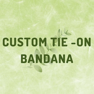 May include: A light green textured background featuring the dark green text CUSTOM TIE-ON BANDANA centered in the image, with a small illustration of a green leafy branch positioned behind the text between the two lines.