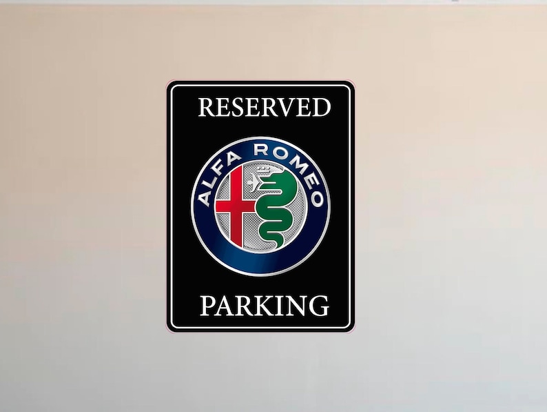 Puede incluir: Letrero rectangular negro con texto blanco &laquo;&nbsp;RESERVED PARKING&nbsp;&raquo;. El letrero presenta el logotipo de Alfa Romeo en un dise&ntilde;o circular con una cruz roja, una serpiente verde y un borde azul.