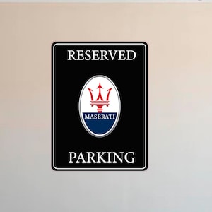 Puede incluir: Letrero rectangular negro con texto blanco &laquo;&nbsp;RESERVED PARKING&nbsp;&raquo;. El logotipo de Maserati est&aacute; en el centro, encima de la palabra &laquo;&nbsp;PARKING&nbsp;&raquo;. El logotipo es un tridente rojo sobre un &oacute;valo azul.