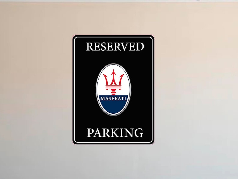 Puede incluir: Letrero rectangular negro con texto blanco &laquo;&nbsp;RESERVED PARKING&nbsp;&raquo;. El logotipo de Maserati est&aacute; en el centro, encima de la palabra &laquo;&nbsp;PARKING&nbsp;&raquo;. El logotipo es un tridente rojo sobre un &oacute;valo azul.