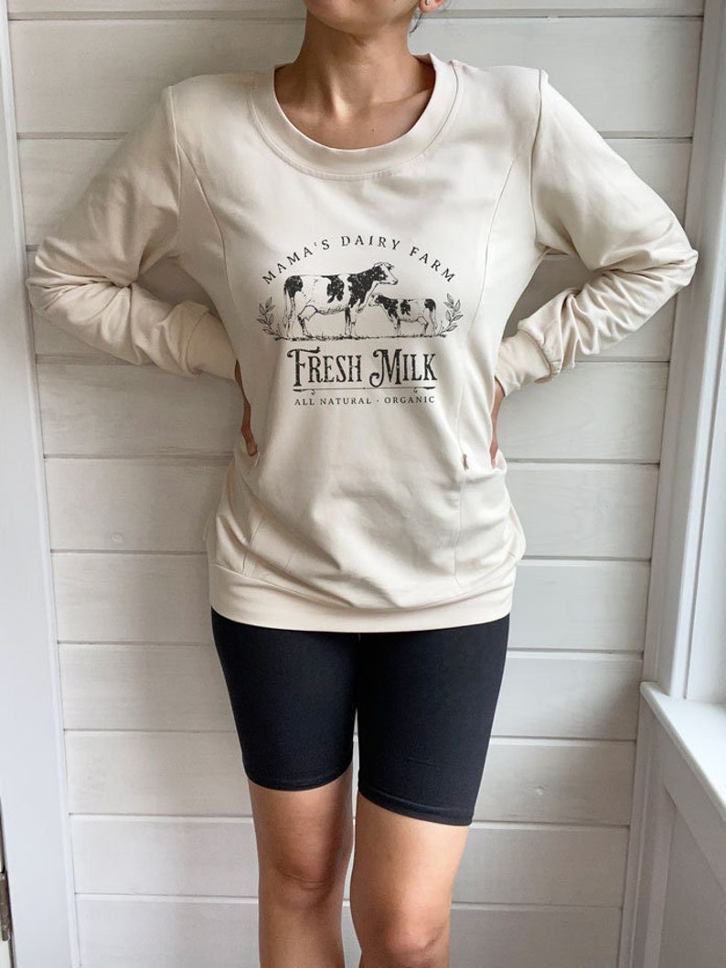 May include: A cream colored sweatshirt with a graphic of cows and the text "Mama's Dairy Farm Fresh Milk All Natural Organic".