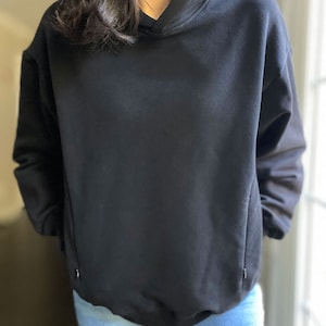 Pu&ograve; includere: Una felpa con cappuccio nera oversize con cappuccio con coulisse. La felpa &egrave; realizzata in un tessuto morbido e confortevole e ha una vestibilit&agrave; rilassata.