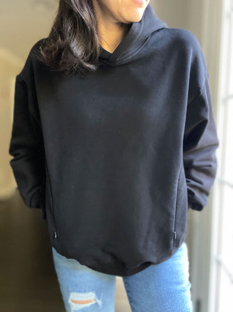 Pu&ograve; includere: Una felpa con cappuccio nera oversize con cappuccio con coulisse. La felpa &egrave; realizzata in un tessuto morbido e confortevole e ha una vestibilit&agrave; rilassata.