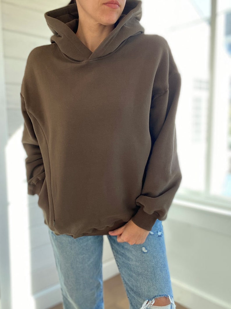 Pu&ograve; includere: Una felpa con cappuccio marrone oversize con coulisse. La felpa &egrave; realizzata in un tessuto morbido e confortevole e ha una vestibilit&agrave; rilassata.