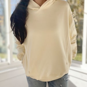 Pu&ograve; includere: Una felpa con cappuccio oversize di colore crema con cappuccio con coulisse. La felpa &egrave; realizzata in un tessuto morbido e confortevole e ha una vestibilit&agrave; rilassata.