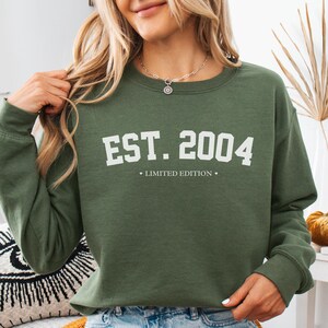 May include: A green sweatshirt with the text "EST. 2004" and "LIMITED EDITION" in white.