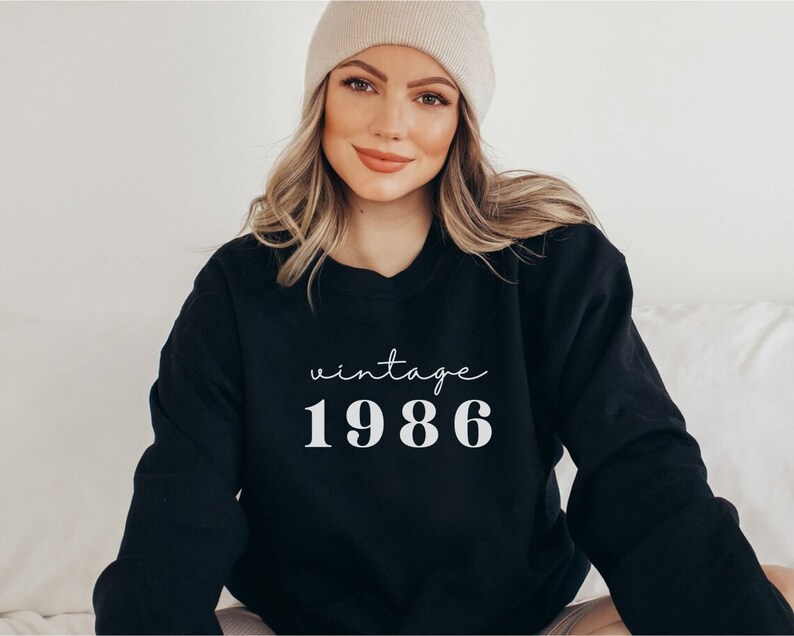May include: Black sweatshirt with white text that reads "vintage 1986".