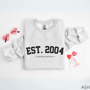May include: Grey sweatshirt with the text "EST. 2004" in black, with the words "LIMITED EDITION" underneath.