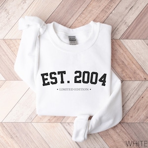 May include: White sweatshirt with black text that reads "EST. 2004 LIMITED EDITION".