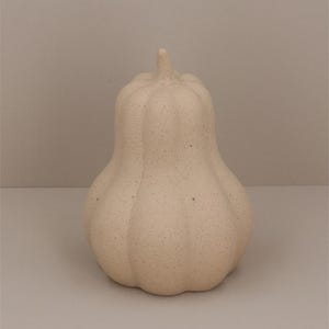 May include: A ceramic gourd-shaped decorative object with a speckled white finish.