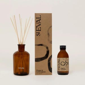 May include: A brown glass diffuser bottle with wooden reeds, a matching bottle of scented oil, and a cardboard box. The box and oil bottle are labeled "St. Eval Ginger & Lemongrass". The diffuser is a home fragrance product.