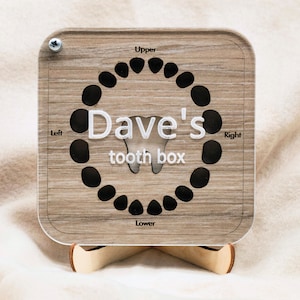 May include: A wooden tooth box with a chart for keeping track of lost baby teeth. The chart is labeled "Upper", "Lower", "Left", and "Right". The box is personalized with the name "Dave's tooth box".