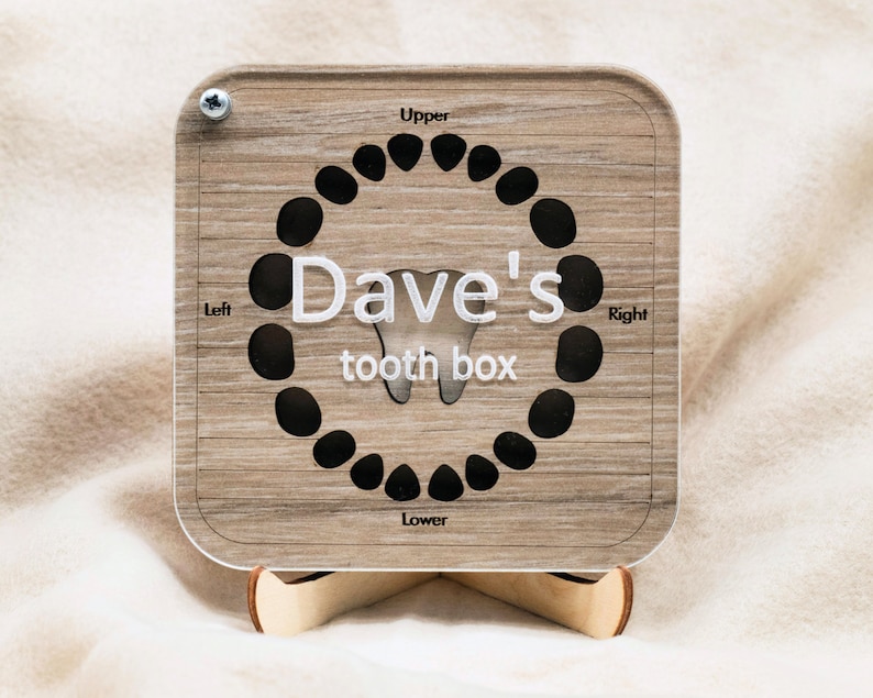 May include: A wooden tooth box with a chart for keeping track of lost baby teeth. The chart is labeled "Upper", "Lower", "Left", and "Right". The box is personalized with the name "Dave's tooth box".