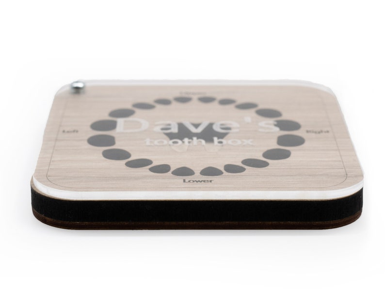 May include: A wooden tooth box with a clear acrylic top. The box has a gray circle with the text "Dave's Tooth Box" and a diagram of teeth. The box has a black border.
