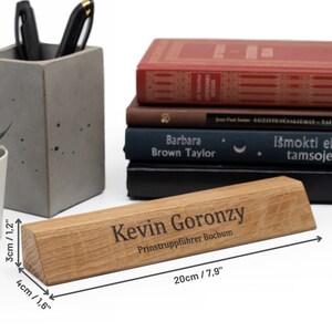 Op de afbeelding: Een houten naamschild voor een bureau met een afgeschuinde rand. Het naamschild is gegraveerd met de tekst "Kevin Goronzy" en "Prinstruppf&uuml;hrer Bochum". Het naamschild is 20 cm lang en 4 cm breed.