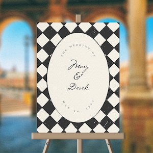 May include: A black and white chequered wedding sign with a white oval in the centre. The oval has the text "The Wedding of Mary & Derek May 24, 2023".