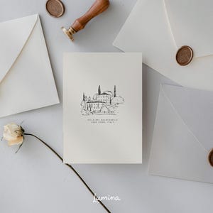 May include: A white card with a black and white illustration of a building with trees and the text "Villa del Balbianello, Lake Como, Italy".