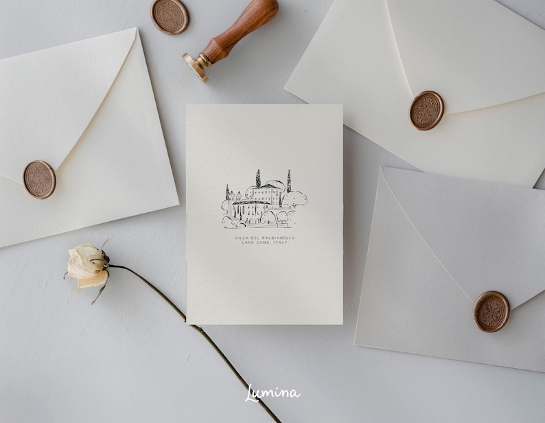 May include: A white card with a black and white illustration of a building with trees and the text "Villa del Balbianello, Lake Como, Italy".
