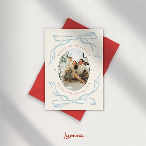 May include: A Christmas card with a blue and white design featuring a family of three in a photo. The text on the card reads "Wishing you the happiest holiday season & new year".