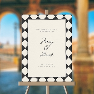 May include: A black and white wedding sign with a diamond pattern border. The sign reads "Welcome to the wedding of Mary & Derek 09.18.2023 New York, NY".