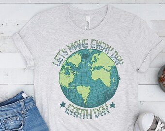 Puede incluir: Una camiseta gris con un gráfico de un globo terráqueo verde y azul y el texto "Let's Make Every Day Earth Day".