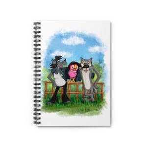May include: Spiral-bound notebook with a cartoon illustration of a wolf, an owl, and a cat. The characters are depicted in front of a wooden fence, with a blue sky and green grass backdrop. The notebook has a white cover.