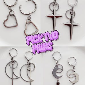 May include: Four pairs of silver-toned earrings with different designs: hearts, starbursts, crescent moons, and geometric shapes. Each earring has a hoop and a dangling charm. The text "PICK TWO PAIRS" is in the center.
