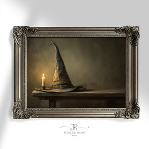 Pode incluir: Uma impressão emoldurada com um chapéu de bruxa e uma vela acesa sobre uma mesa de madeira. O chapéu é cinza-marrom suave com uma coroa pontuda e aba larga. A vela está em um castiçal de prata, emitindo um brilho quente. A moldura é ornamentada.