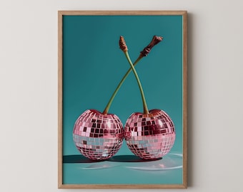 May include: Framed art print featuring two cherries with disco ball-like surfaces. The cherries have green stems that cross each other against a teal background. The frame is made of light brown wood.