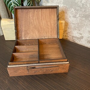 May include: A wooden box with a hinged lid and a divided interior. The box is engraved with the words "you do not yield".