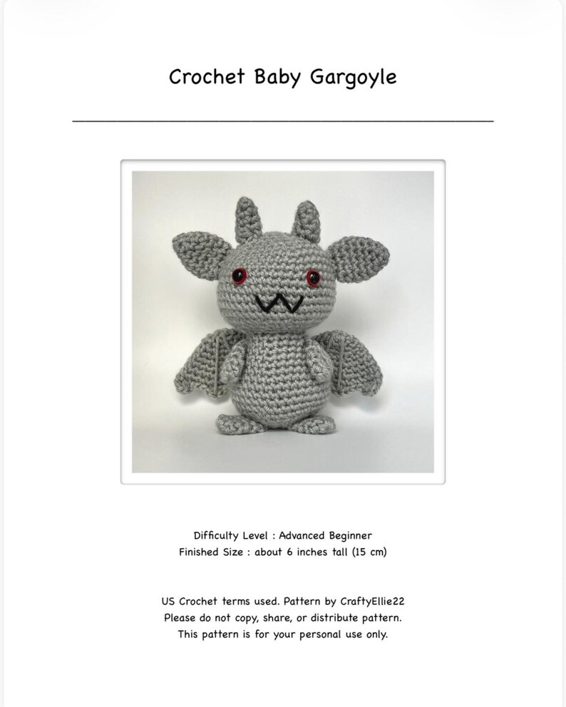 Op de afbeelding: Een gehaakte grijze baby-waterspuwer met rode ogen, vleugels en kleine hoorns. De tekst "Crochet Baby Gargoyle" staat bovenaan. De afmeting is ongeveer 15 cm hoog.