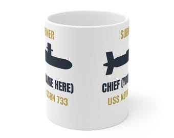 May include: A white ceramic mug featuring dark blue submarine silhouettes and gold text. The text includes SUBMARINER, (YOUR NAME HERE), SSBN 733, CHIEF (YOUR NAME HERE), and USS NEVADA. The design is printed on the exterior surface of the mug.
