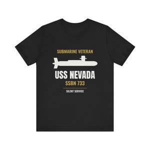 May include: A black short-sleeve t-shirt featuring a white graphic of a submarine. Text in gold and white reads: SUBMARINE VETERAN, USS NEVADA, SSBN 733, and SILENT SERVICE. The design is centered on the chest of the shirt.
