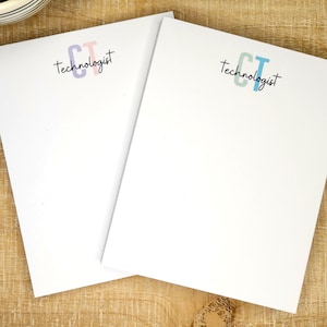 May include: Two white notepad sets with the text "CT Technologist" and a blue and green "CT" logo on one notepad and a pink and purple "CT" logo on the other notepad.