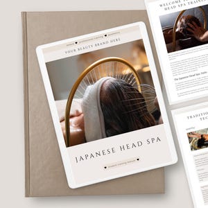 Op de afbeelding: Een digitale tablet toont "JAPANESE HEAD SPA" met een afbeelding van een hoofdspa-behandeling. De tablet ligt op een beige boek, met andere pagina's met details over hoofdspa-training en massagetechnieken.