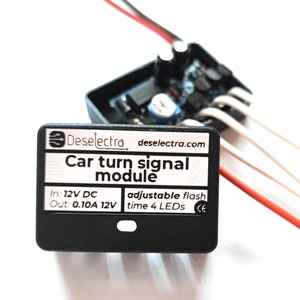 Op de afbeelding: Een zwart knipperlichtmodule voor auto's met de tekst "Deselectra" en "Car turn signal module". De module heeft draden en elektronische componenten zichtbaar. De tekst op de module luidt "In: 12V DC Out: 0.10A 12V adjustable flash time 4 LEDs".