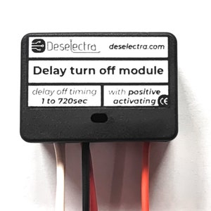Op de afbeelding: Zwarte vertraagde uitschakelmodule met witte tekst die "Deselectra deselectra.com Delay turn off module delay off timing 1 to 720sec with positive activating CE" luidt.