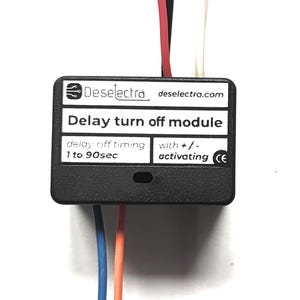 Può includere: Un modulo di spegnimento ritardato nero con fili colorati. Il modulo ha il testo "Deselectra" e "Delay turn off module". Visualizza anche "delay off timing 1 to 90sec" e "with +/- activating".