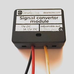 May include: A black signal converter module with the text "Deselectra" and "Signal convertor module". It has red, yellow, and black wires extending from the bottom. The module has the text "12V DC" and "adjustable out: 0-10sec pulse".
