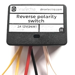May include: A black reverse polarity switch, labelled "Reverse polarity switch" with the brand name "Deselectra". It features multiple coloured wires, including yellow, red, black, and white. The switch is designed for 12V (24W) applications. The website deselectra.com is also visible.
