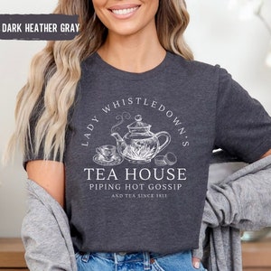 May include: Dark heather gray t-shirt with a white graphic of a teapot and the text "Lady Whistledown's Tea House Piping Hot Gossip...and tea since 1813."