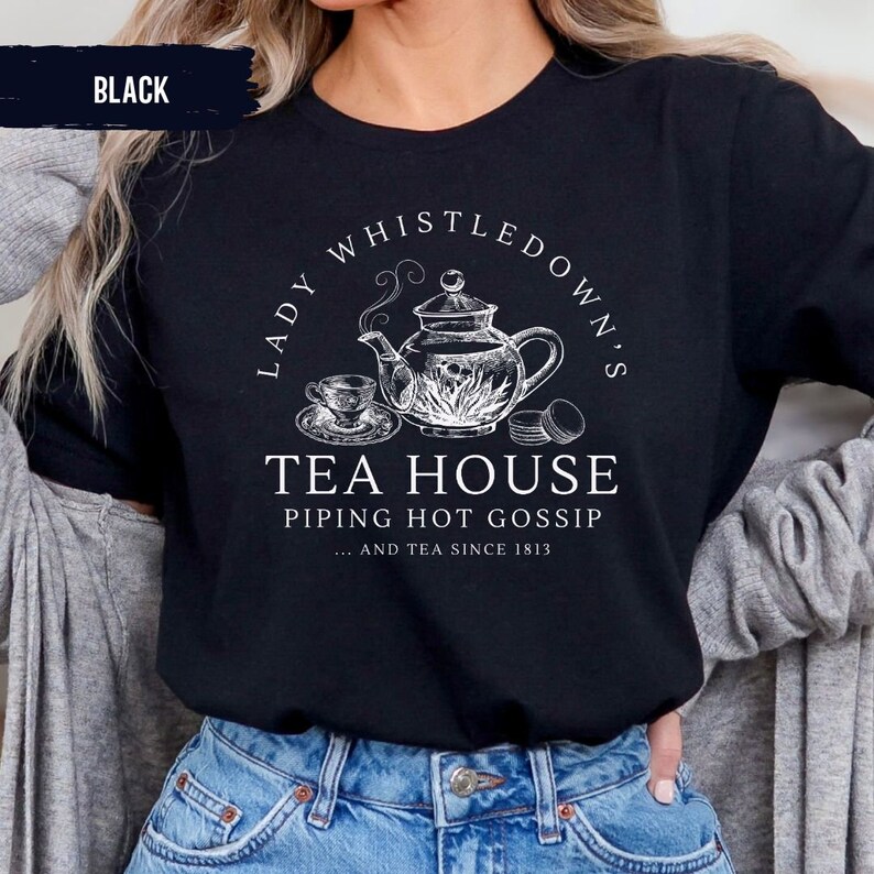 May include: Black t-shirt with a white graphic of a teapot, teacup, and macarons. The text reads "Lady Whistledown's Tea House Piping Hot Gossip... and tea since 1813."