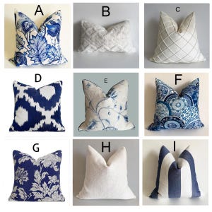 May include: A collection of nine square and rectangular scatter cushions labelled A to I. The cushions feature various patterns including blue and white floral prints, geometric diamond stitching, solid white textured fabric, and blue and white stripes.