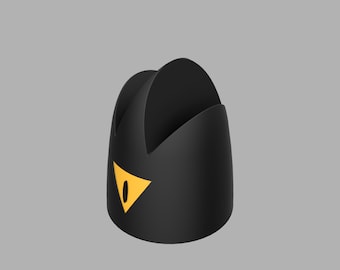 May include: A black, stylized phone stand with a yellow eye-shaped design. The stand has a curved, open design and a triangular yellow accent. The stand is on a gray background.