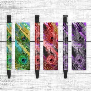 Könnte beinhalten: Fünf schwarze Stifte mit verschiedenen Pfauenfeder-Designs. Die Designs umfassen Grün, Gold, Rot, Lila und silbernen Glitzer.